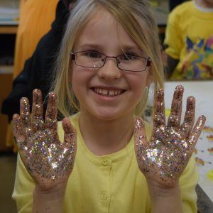 student with glitter hands