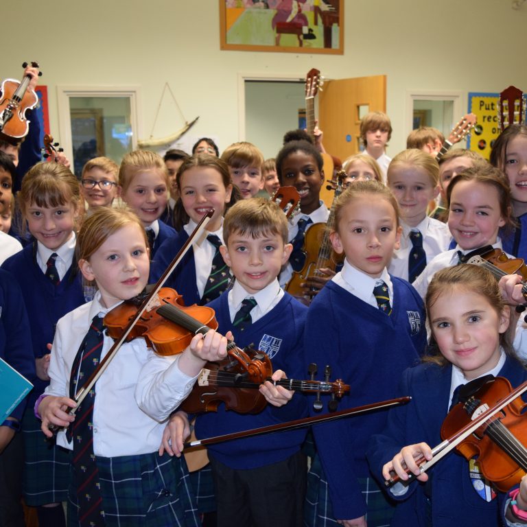 group of music students holding up their instruments