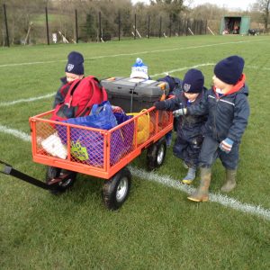 children walking next to a cart of outdoor equipment